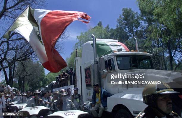 Truck transports Zapatistas accompanied by police in a caravan to Mexico City 11 March 2001. Un camion que transporta zapatistas es custodiado por...