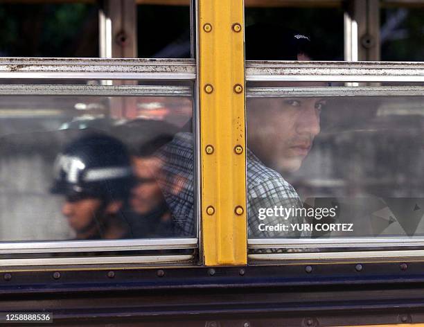 Passenger on a government run bus is seen observing military police in San Salvador, El Salvador 28 November 2001. Un pasajero que viaja en un...