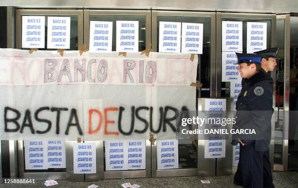 Two police officers guard the entrance of a bank in Buenos Aires, Argentina 30 November 2001. Dos integrantes de la Policía Federal patrullan frente...