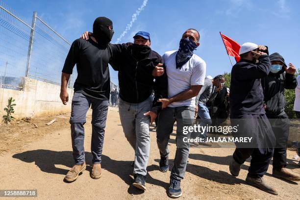 Members of the Druze community carry a demonstrator injured during a protest in their village of Majdal Shams in the Israel-annexed Golan Heights on...