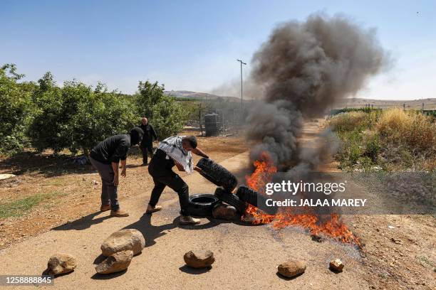 Members of the Druze community set tires aflame as they protest against an Israeli wind turbine project reportedly planned in agricultural lands in...