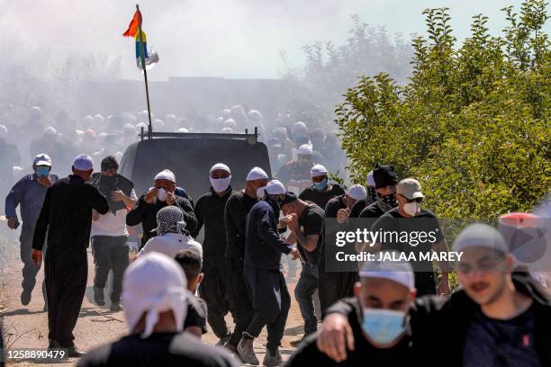 Tear gas fumes fill the air as members of the Druze community gather in a protest against an Israeli wind turbine project reportedly planned in...