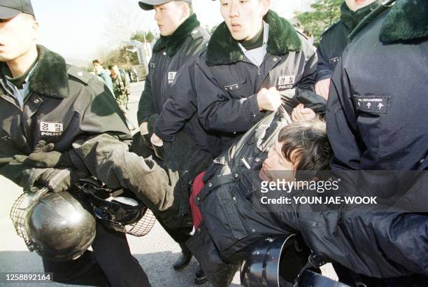 South Korean police carry away an anti-US protester 19 February 2002 during a protest at the gate of Seoul airport military base while US President...