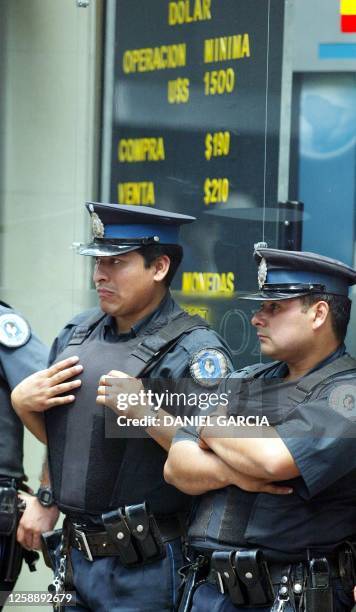 Policemen patroling infront of the Banco Velox 22 February 2002 in Buenos Aires. The bank offers a buying rate of 1.90 dollars for 2.10 selling rate....
