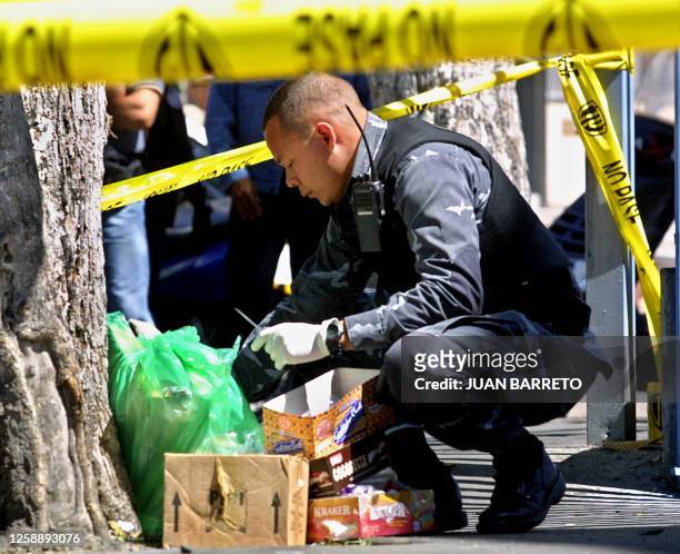 Member of the Venezuelan bomb squad is seen checking the remains of the remains of an explosive that injured two workers 24 January 2002 in Caracas,...