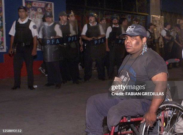 An invalid is seen waiting in vain for food in front of supermarket 19 Decmber 2001. Un invalido espera en vano una bolsa con comida frente a un...