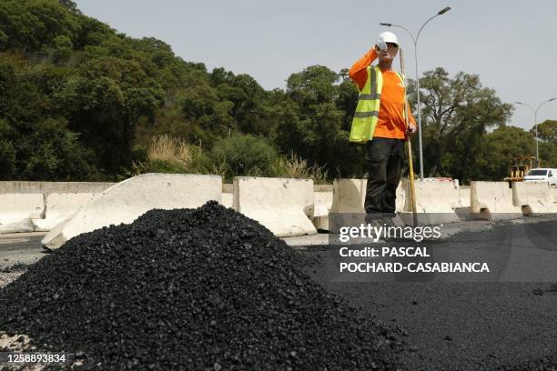 An employee is at work on a road construction under 39 degres Celcius during a heat wave the French Mediterranean island of Corsica, outside Ajaccio...