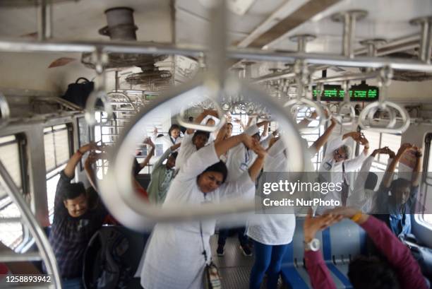 Women perform yoga on the day of International Yoga Day inside suburban train compartment in Mumbai, India, 21 June, 2023.