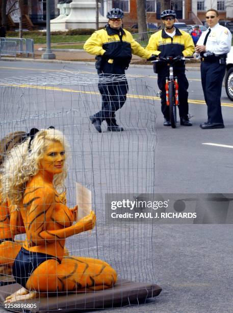 Members of the US Secret Service Uniformed Division keep a sharp eye on protesters Kayla Worden of Ashville, North Carolina, who used body paint to...