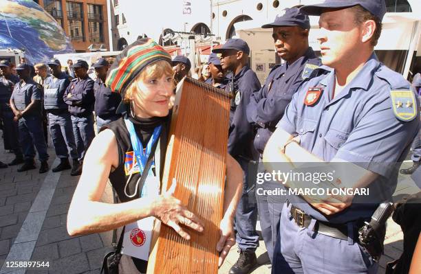 Delegate plays music as she stages a peaceful protest with around 20 others at Sandton Square after leaving the World Summit on Sustainable...