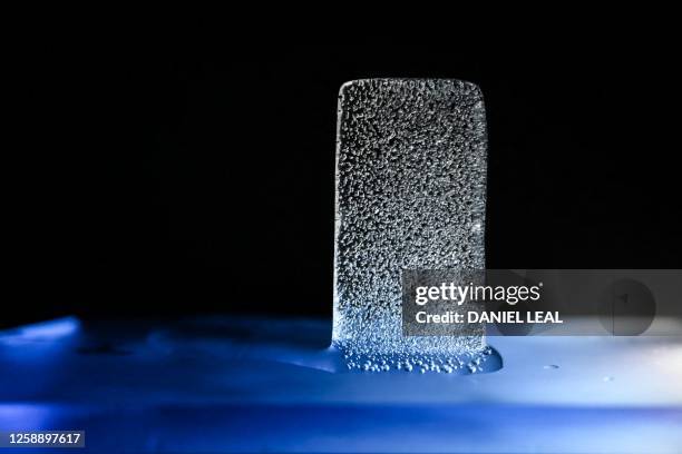 Photograph taken on June 19, 2023 shows a piece of ice collected in the Antarctic containing gas bubbles that will be analysed in the lab, and...