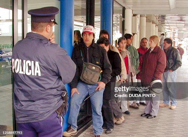 Civilians wait in line for the re-opening of the Banco Republica, 05 August 2002, in ciudad Rivera, 500 km north of Montevideo. Ahorristas esperan la...