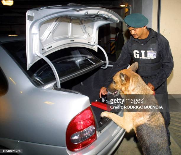 An anti-explosives police agent checks a car with his dog in the parking lot of the hotel where the II Meeting of South American Presidents will take...
