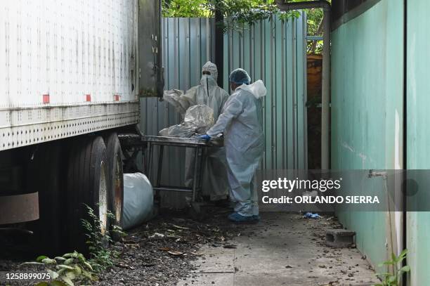 Forensic employees transport the corpses of several of the 46 dead women during a fire following a brawl between inmates of the Women's Social...