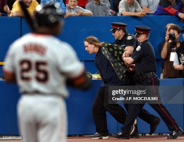 Police remove a field-running fan as San Francisco Giant slugger Barry Bonds waits to resume play in the top of the ninth inning against the Toronto...