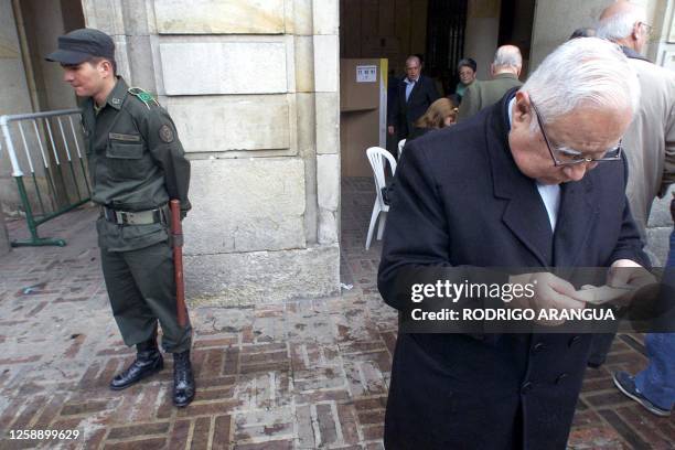 An elderly man looks at his identification card after casting his vote in Bogota, Colombia, 26 May 2002. War-weary Colombians went to the polls 26...