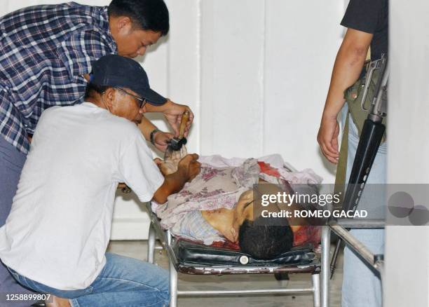 Police investigators takes a fingerprint on the slain alleged Abu Sayyaf Muslim rebel leader Bakal Hapilon the brother of Isnilon Hapilon, top leader...