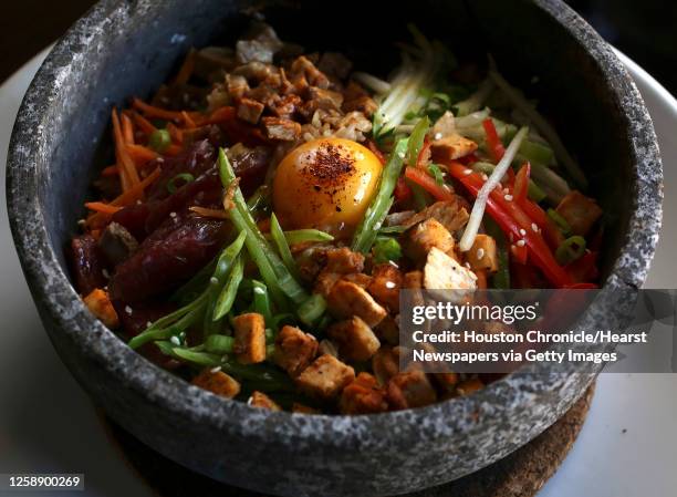 The Volcano Rice dish: with pork, Chinese sausage, chicken, special rice, carrots, zucchini, red bell peppers, snow peas, green onions, white sesame...