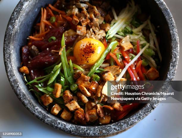 The Volcano Rice dish: with pork, Chinese sausage, chicken, special rice, carrots, zucchini, red bell peppers, snow peas, green onions, white sesame...