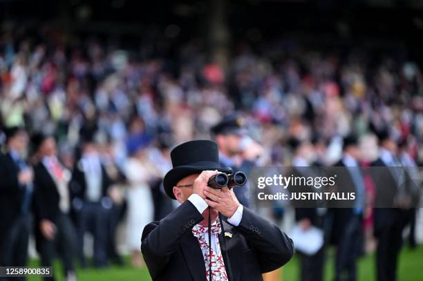 Racegoer uses binoculars to watch the Duke Of Cambridge Stakes race on the second day of the Royal Ascot horse racing meeting, in Ascot, west of...