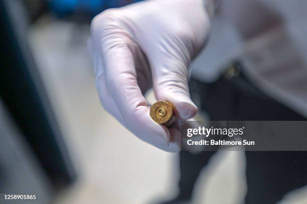 Inside the firearms range, forensic scientist ZoÃ« Krohn holds a spent shell casing during the Forensic Science &amp; Evidence Division Open House,...