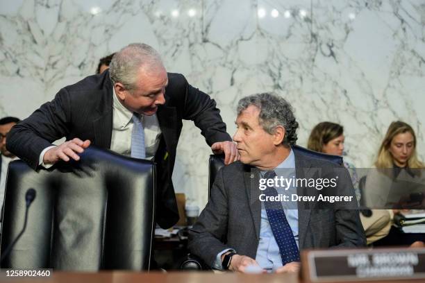 Sen. Chris Van Hollen talks with committee chairman Sen. Sherrod Brown during a Senate Banking nominations hearing on June 21, 2023 in Washington,...