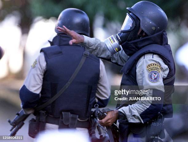 Venezuelan metropolitan police fire toward colleagues supporting a takeover by Venezuelan President Hugo Chavez's government, which took control of...
