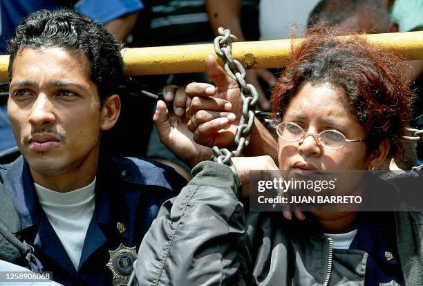 Metropolitain Police officers chain themselves to the headquarters during a protest in Caracas, Venezuela, 07 October 2002. The government has...