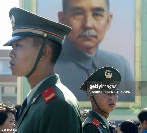 Paramilitary police keep an eye on crowds beneath a portrait of Sun Yat Sen, considered the founder of modern China after helping overthrow dynastic...