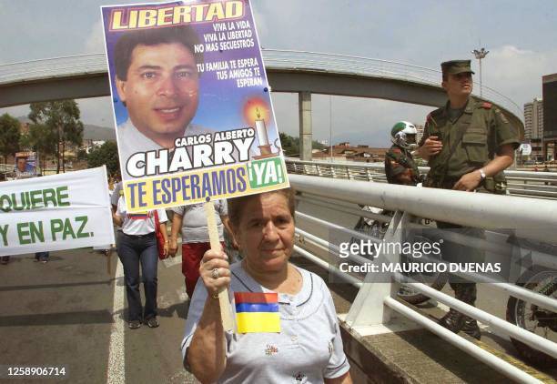 Demonstrator is seen on the streets of Cali, Colombia 30 August 2002. Una manifestante porta un afiche con la foto del diputado Carlos Alberto...