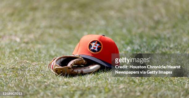 Hat and glove lie on the ground during the first day of spring training workouts for pitchers and catchers at their Osceola County training facility,...