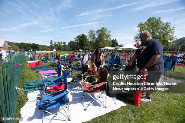 Jesus Vasquez and Pamela Lott, of Houston, get set up for Sunday's induction by staking out a spot with folding chairs near the Baseball Hall of Fame...