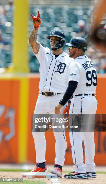 Javier Baez of the Detroit Tigers celebrates with third base coach Alfredo Amezaga after getting his 1000th hit during the third inning of a game...