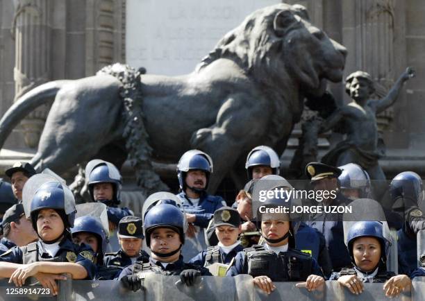 Mexican police guard 05 February Mexico City's Independence Monument during a demonstration against the North American Free Trade Agreement . Some 19...