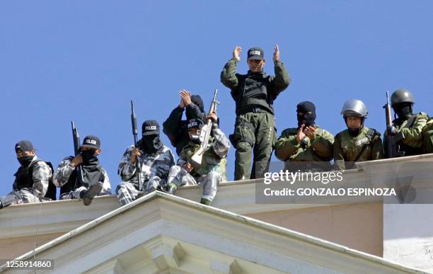 Military policemen take up positions on top of a building 12 February, 2003 in La Paz during a protest by students rallying against economic reforms....