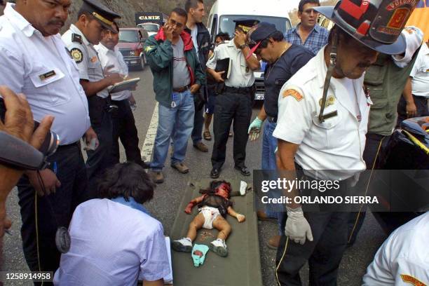 Firefighters and police investigate the scene where a family was massacred in Amatitlan, Guatemala with the body of Wilmer Esquite lying on the...