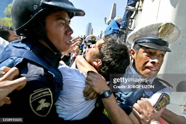 Mexican police arrest a protester 05 February at Mexico City's Independence Monument during a demonstration against the North American Free Trade...