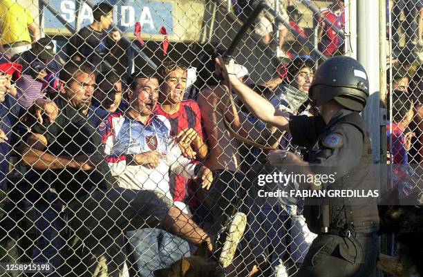 Anti-riot police secure the area as soccer fans attempt to break through the fence in Buenos Aires, Argentina 01 December 2002. Simpatizantes de San...