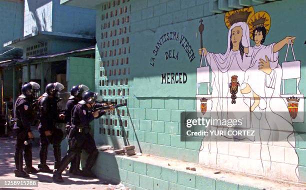 Police officers fire their weapons inside the Esperanza "Mariona" Penitentiary in Mejicanos, El Salvador after prisoners sieged a cell block in order...