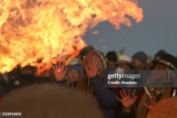 The president of Bolivia, Luis Arce Catacora, raises his hands to receive the first rays of sun to celebrate the Amazon Andean New Year near the...
