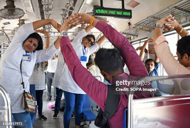 Yoga teachers show commuters a form of yoga exercise inside the local train compartment on the occasion of International Yoga Day. 9th International...