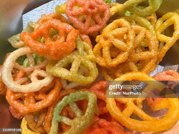 Woman preparing Far Far Chakra Fryums in Toronto, Ontario, Canada, on June 21, 2023. Far-far is an Indian snack food composed primarily of potato...