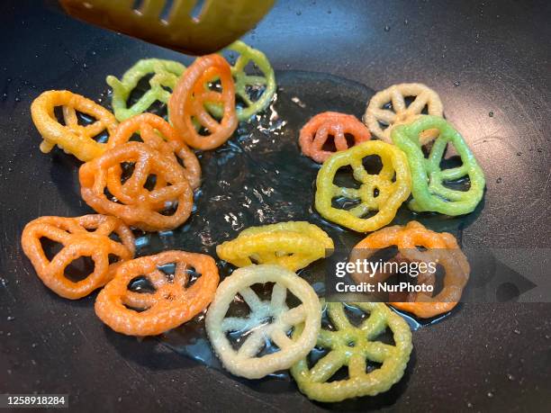 Woman preparing Far Far Chakra Fryums in Toronto, Ontario, Canada, on June 21, 2023. Far-far is an Indian snack food composed primarily of potato...