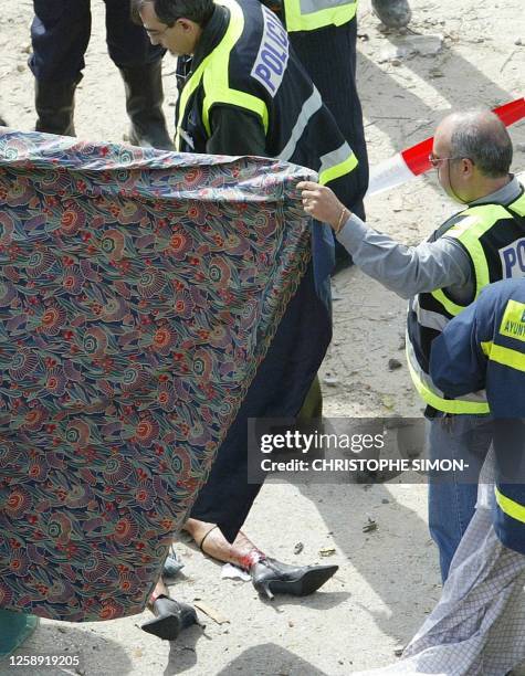 The body of a victim is hidden before being evacuated after a train exploded near the Atocha train station in Madrid 11 March 2004. At least 173...