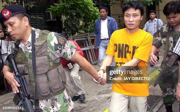 Heavily armed police escorts lead alleged Moro Islamic Liberation Front bomb expert Saifullah Mukhlis Yunos to a waiting van after his arraignment,...