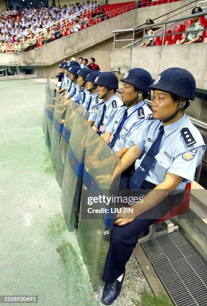 Chinese police stand guard during a soccer match between the Shanghai Shenhua SVA and the Tianjin Kangshifu as matches in China's soccer Division A...