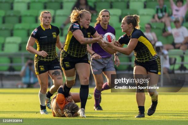 Pittsburgh Steeltoes player Sara Kaljuvee hands the ball off to teamate Pittsburgh Steeltoes player Brooklynn Feasby while being tackled by Texas...