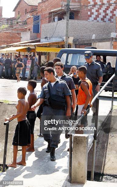 Police stand guard near a military police bus 22 April that was attacked by drug traffickers in the favela Baixa do Sapateiro, on the outskirts of...