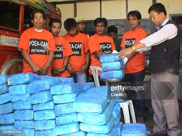 Anti-narcotics police superintendent Edgardo Perez shows the seized processed marijuana bricks together with the five suspects following their arrest...