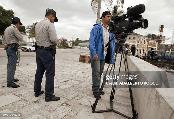 Police officers are seen checking a camera man's identification papers in La Habana, Cuba following yesterdays theft of a boat by immigrants heading...
